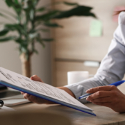 Unrecognizable businesswoman going through reports while working in the office.